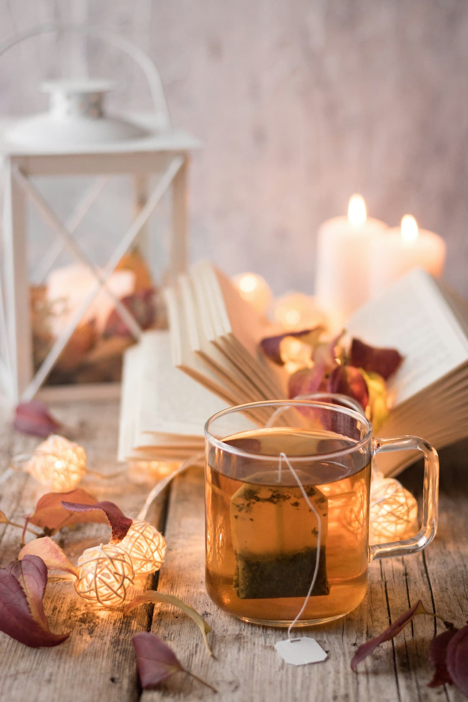 A square paper tea bag steeping in a glass mug of amber tea